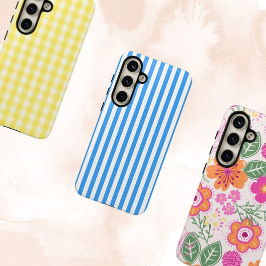 Cute Samsung Galaxy phone cases including yellow checkered, blue striped, and floral designs on a pink background