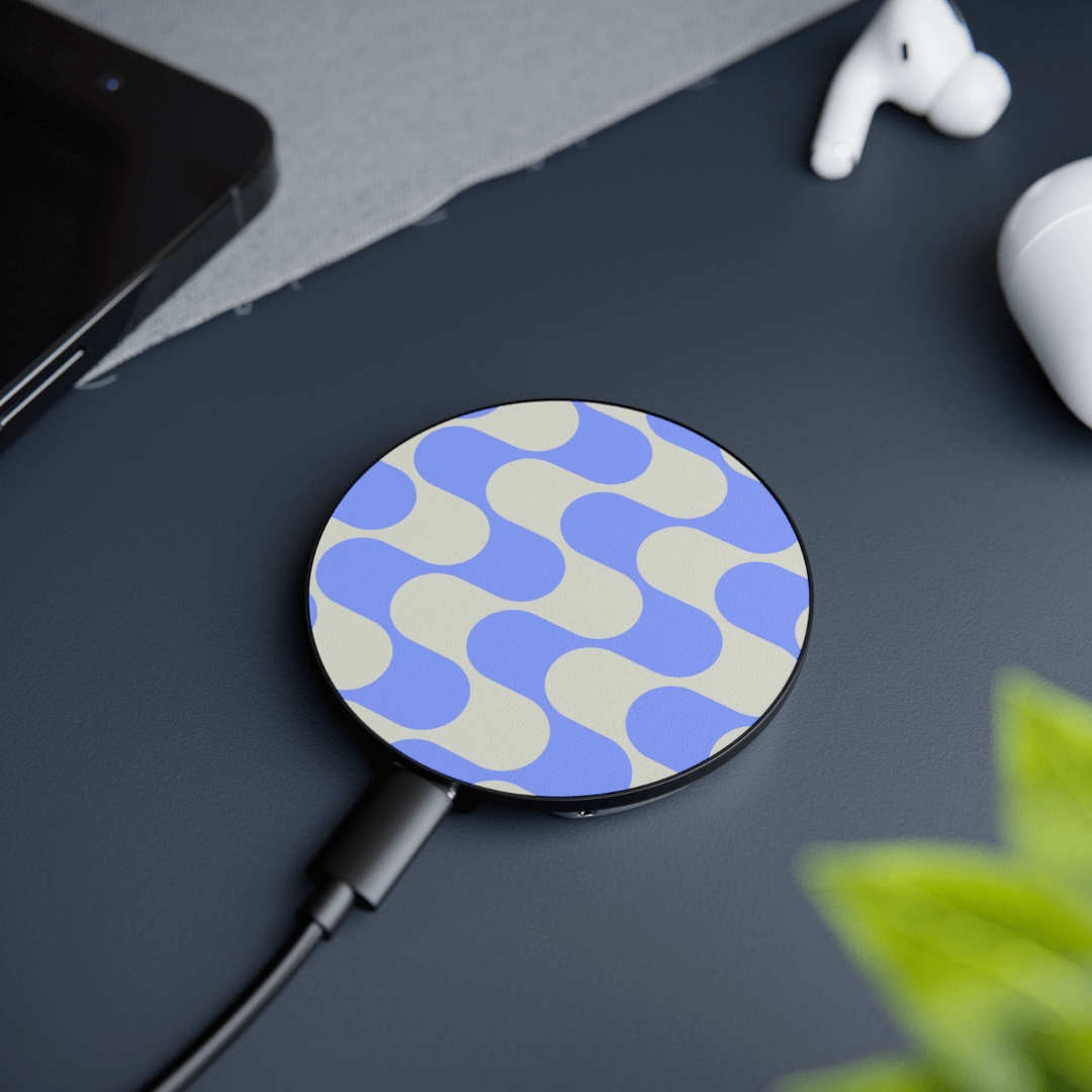 Stylish wireless charger with geometric pattern, compatible with MagSafe technology, on a desk with phone and earbuds.